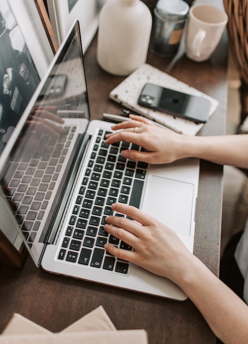 crop female freelancer using laptop at table at home