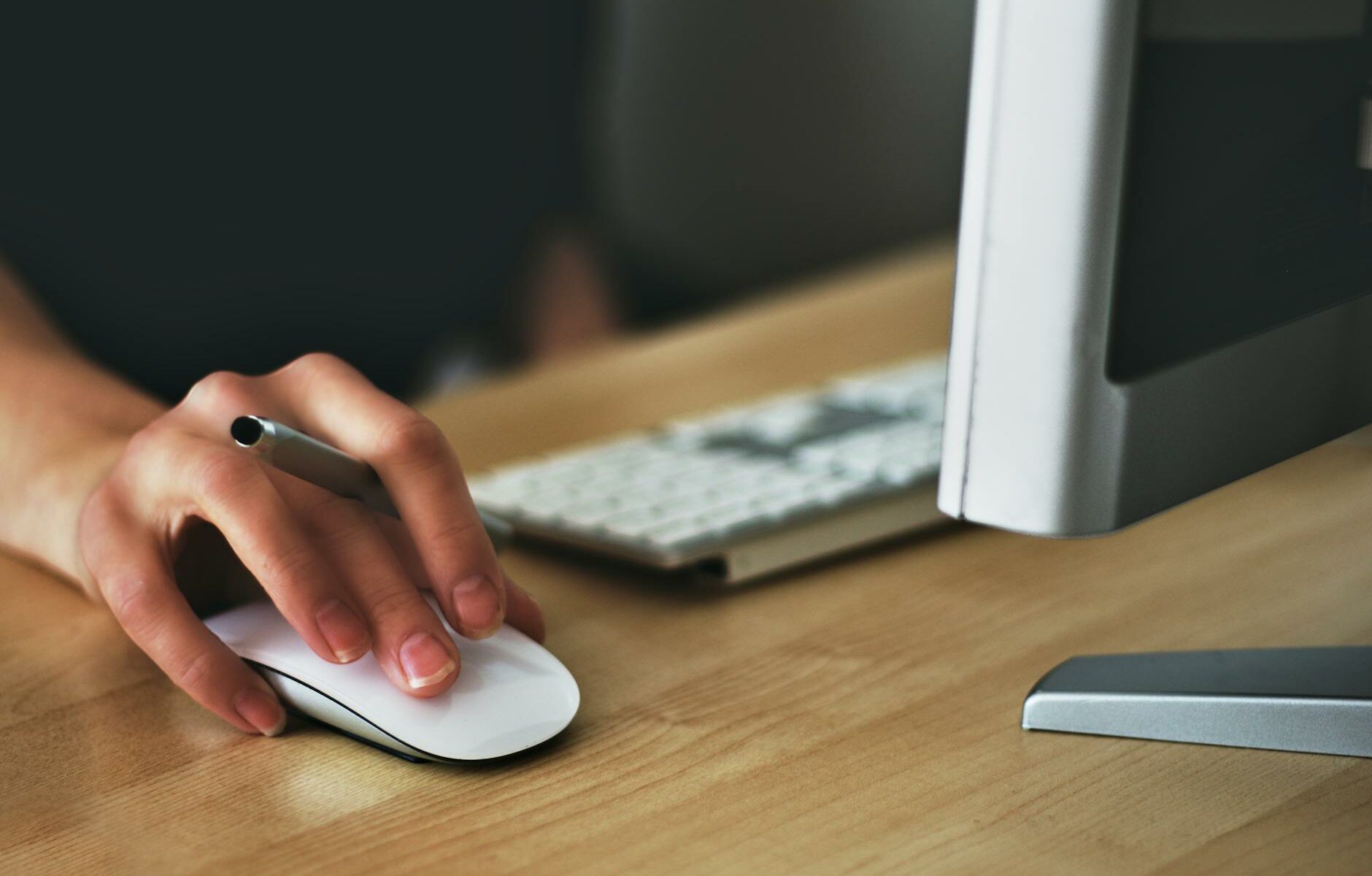 person holding apple magic mouse